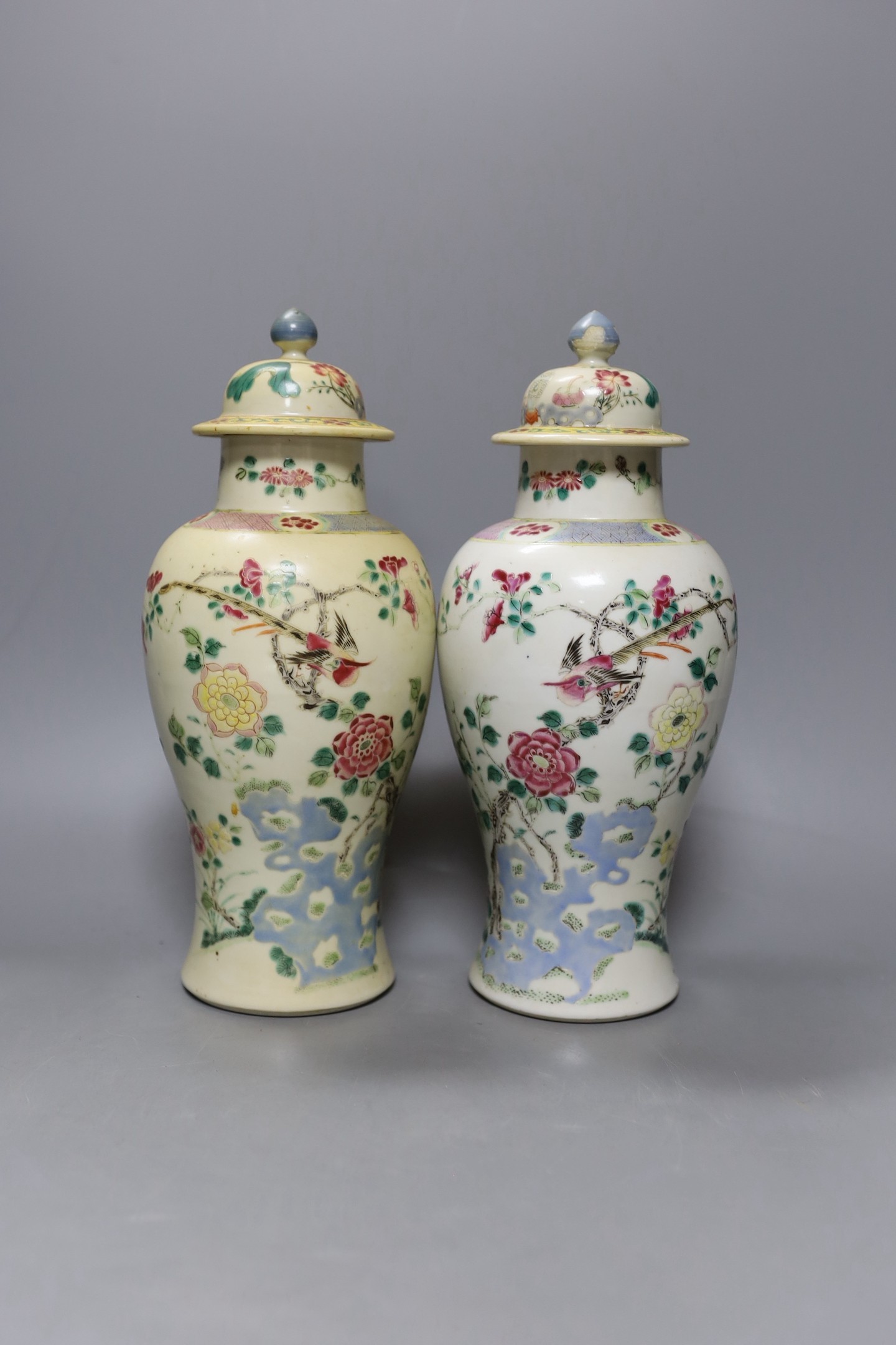 A pair of 19th century Chinese famille rose vases and covers - 27cm tall